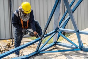 worker cutting steel with reciprocating saw
